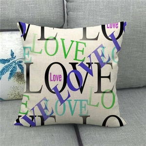 Close-up of linen pillowcase with colorful LOVE text patterns on a gray sofa