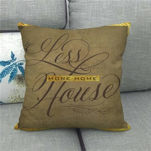 Detailed close-up of linen cushion with More Home text on a dark gray sofa