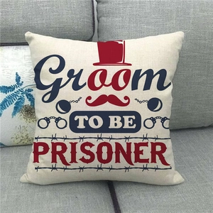 Funny 'Groom To Be' linen pillow case with handcuffs graphic on a gray fabric sofa