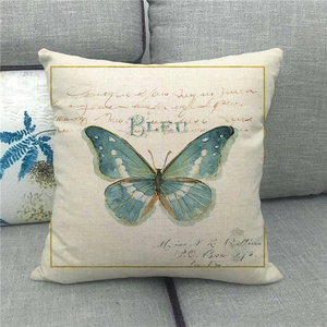 Linen pillowcase with vintage blue butterfly and cursive script on a grey sofa