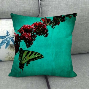 Detail of linen pillowcase with green butterfly and red flowers on a dark teal background