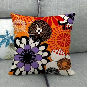 Linen pillowcase with colorful geometric abstract daisy flower print on a grey sofa