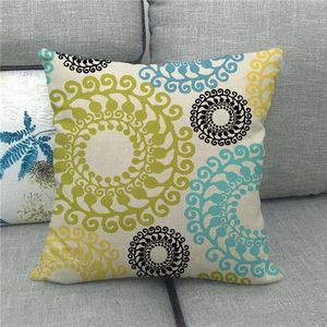 Detail view of linen pillowcase with geometric floral pattern on a grey sofa
