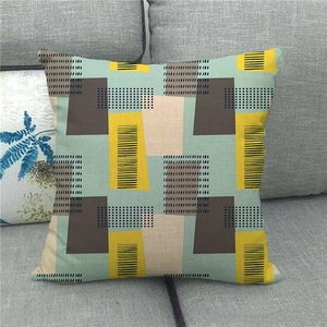 Detailed texture of geometric linen pillowcase with yellow and blue blocks on grey sofa