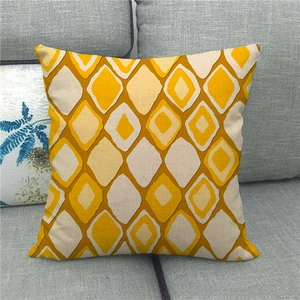 Close-up of geometric diamond pattern on linen cushion cover on a grey sofa