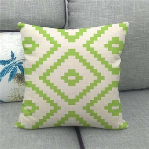 Linen square pillow cover with green geometric diamond pattern on grey sofa