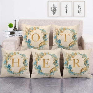 Detail of five linen pillowcases with nautical sea life patterns and gold alphabet letters