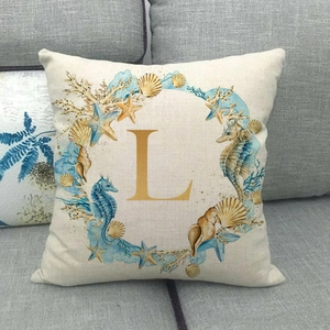 Detailed close-up of a linen pillowcase featuring a watercolor seahorse and letter L