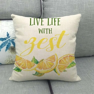 Linen cushion cover with lemon print and zest slogan on a modern gray sofa