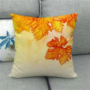 Housse de coussin en lin avec feuille d'érable d'automne sur un canapé gris