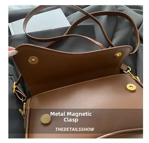 Detail of premium gold magnetic clasp closure on the dark brown leather shoulder bag