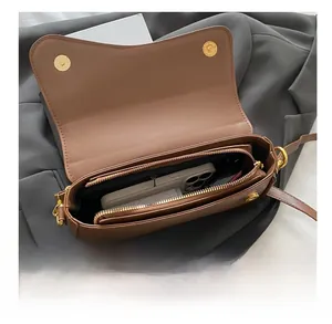 Spacious interior of brown crossbody bag showing zipper pocket and phone compartment