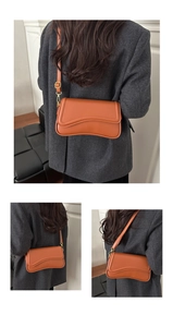 Detail of caramel brown PU leather crossbody bag with wave design and adjustable strap