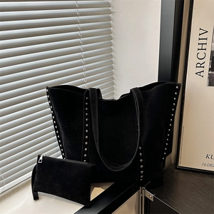 Detail of black suede tote bag with silver studs and matching interior pouch set