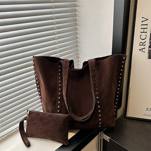 Detail of dark brown suede tote bag with silver studs and matching interior pouch