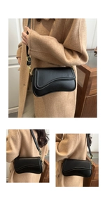 Detail of black leather shoulder bag with wavy edge cover and gold metal hardware