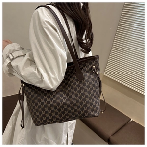Detailed view of the large capacity tote bag featuring brown monogram M pattern and leather strap