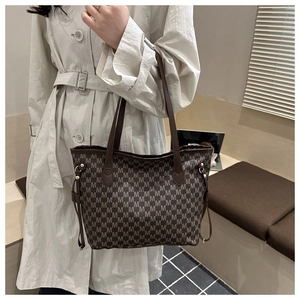 Detail of large brown tote bag with M-letter pattern and adjustable side drawstrings