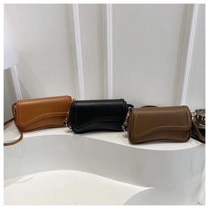 Chic wave-bottom crossbody bags in brown, black and coffee on a minimalist pedestal