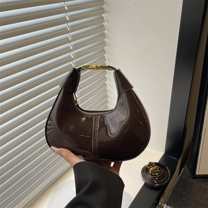 Sac croissant en cuir verni marron foncé avec poignée dorée et bandoulière élégante