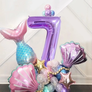 Macro detail of mermaid tail and shell foil balloons in purple and blue birthday set