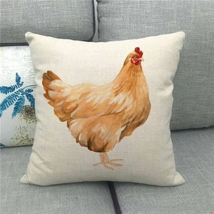 Detail of linen cushion cover featuring watercolor chicken art on a grey fabric sofa
