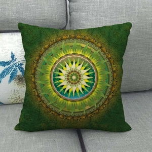Detailopname van linnen kussenhoes met groene mandala print op een grijze bank