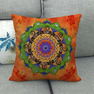 Gedetailleerde textuur van oranje linnen kussensloop met mandala libelle en bloemen