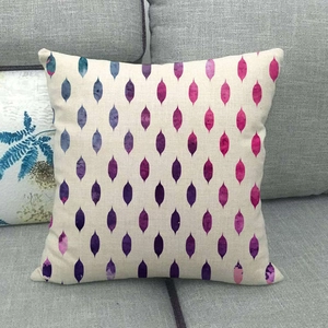 Linen decorative pillow cover with colorful geometric watercolor leaf patterns on a sofa