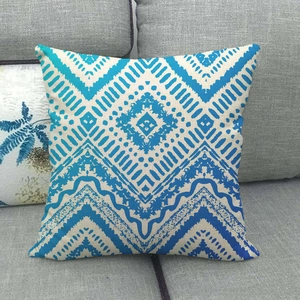Housse de coussin minimaliste en lin bleu et crème avec motifs géométriques sur canapé