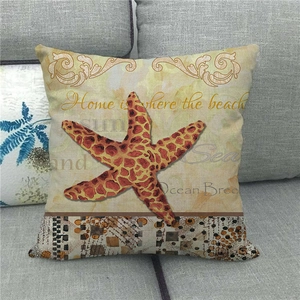 Linen pillowcase with starfish and ocean theme print on a modern grey fabric sofa