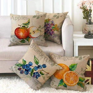 Detailed set of four linen pillow covers featuring fruit illustrations on a cozy sofa