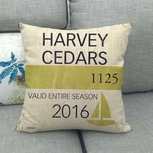 Linen pillow cover with vintage Harvey Cedars design on a gray sofa background