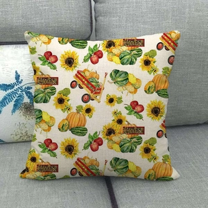 Close-up of linen pillow cover with harvest pumpkin and sunflower prints on gray sofa