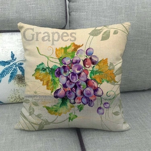 Linen pillow cover with watercolor grape print on a gray sofa in a modern setting