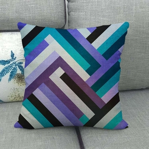 Linen square pillow case with colorful geometric stripes on a gray fabric sofa