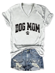 Flat lay of white Dog Mom V-neck t-shirt with hollow paw print and distressed denim shorts