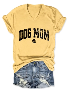 Close-up of yellow V-neck T-shirt with black Dog Mom print and distressed denim shorts