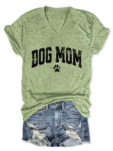 Close-up of light green V-neck Dog Mom T-shirt with vintage print and denim shorts