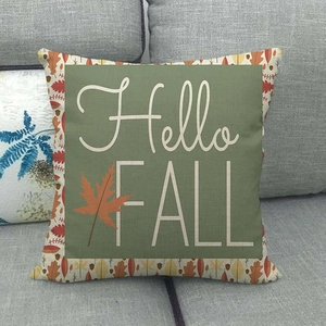 Detail of Hello Fall linen pillowcase with autumn maple leaves on a grey fabric sofa