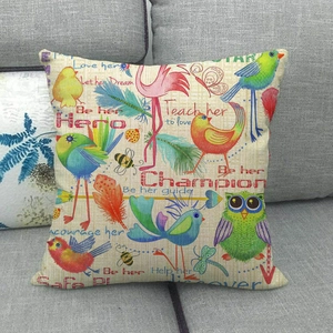 Linen cushion cover featuring colorful bird and feather prints on a gray sofa background
