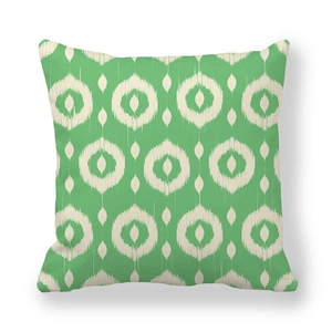 Thick peach skin pillowcase with green and cream geometric ikat pattern on white backdrop