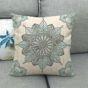 Linen cushion cover with mandala geometric pattern on a gray sofa in minimalist style