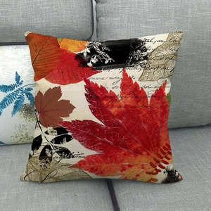 Linen pillowcase with autumn maple leaves and script on a grey sofa