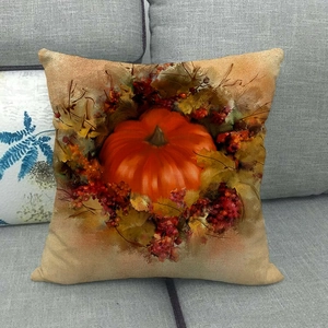 Autumn linen pillowcase with watercolor pumpkin and maple leaf design on gray sofa