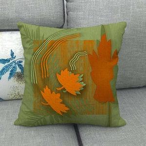 Detail of autumn maple leaf pattern on moss green linen pillow case on grey sofa