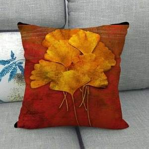 Close-up of linen pillowcase with yellow ginkgo leaf pattern on a grey sofa