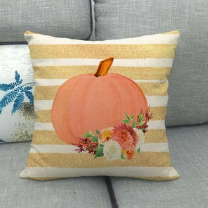 Close-up of linen pillowcase with pumpkin and floral pattern on a grey sofa
