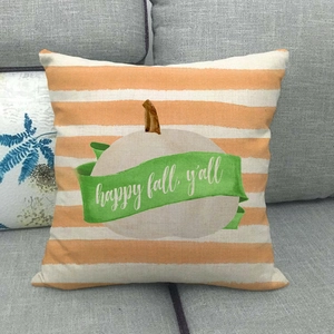 Detail of fall pumpkin linen pillow cover with happy fall text on a grey sofa