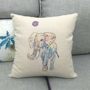 Federa per cuscino in lino con elefante ad acquerello su un divano grigio